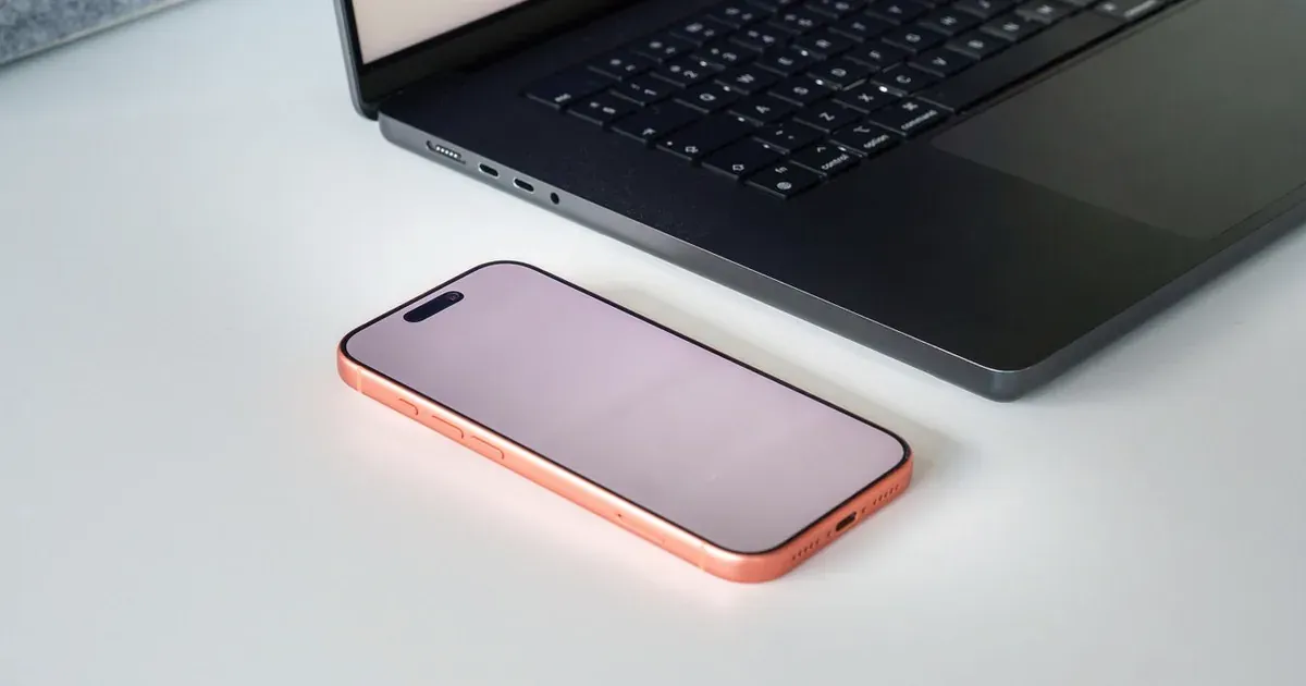 Smartphone junto a una laptop para estimar el desarrollo de una aplicación móvil