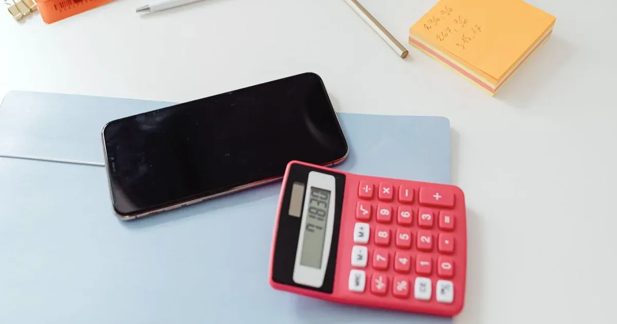 Smartphone y calculadora para estimar el costo de una página web